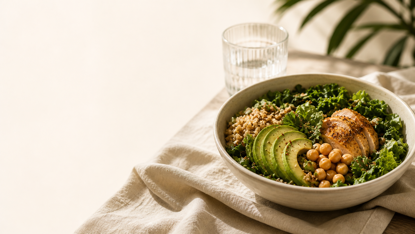 A nourishing grain bowl with avocado, kale, and chickpeas in warm light